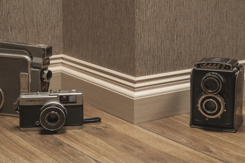 Light foil-wrapped MDF skirting with a moulded top edge in a room corner